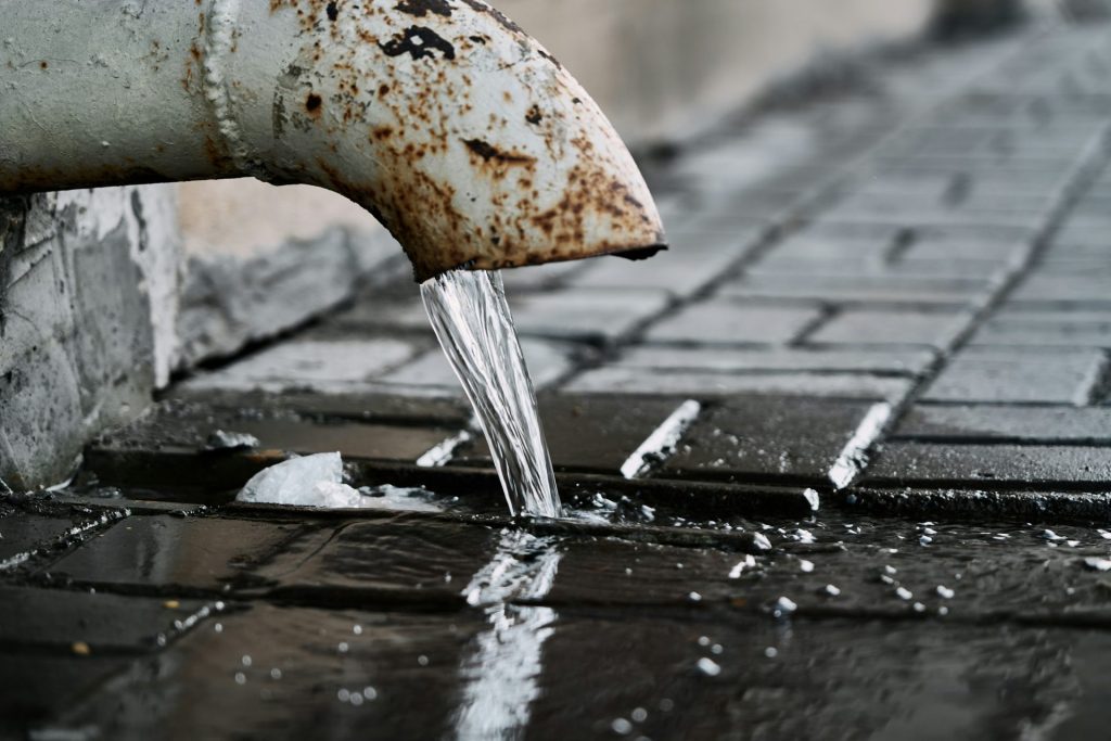 a rusty pipe with water coming out of it