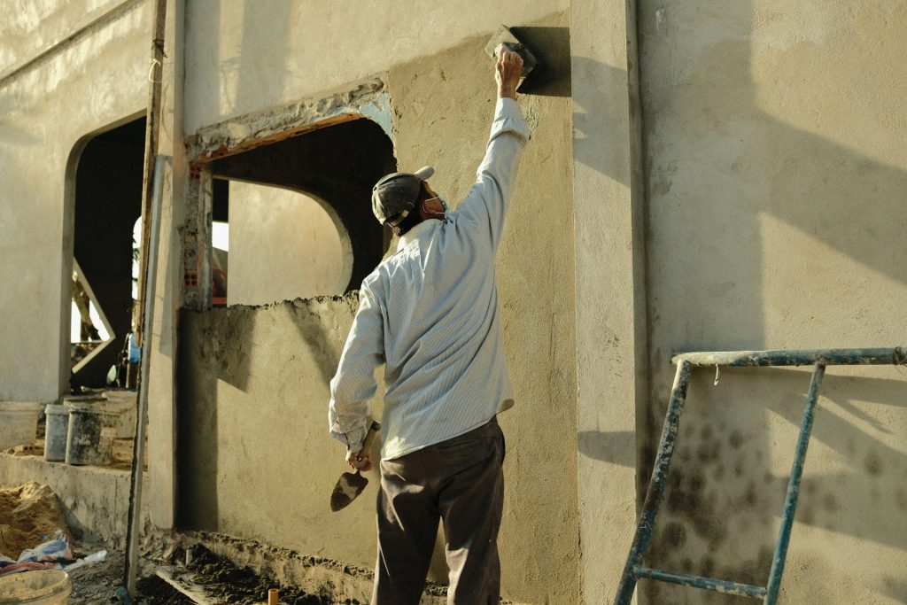 a man standing next to a building with a hammer