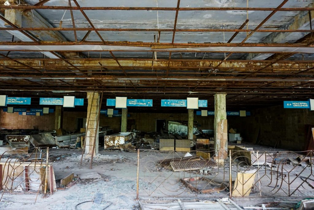 an abandoned building with a bunch of chairs and tables
