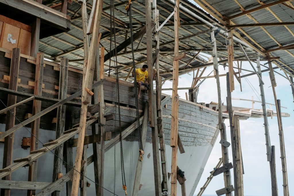 a man standing on the side of a boat under construction